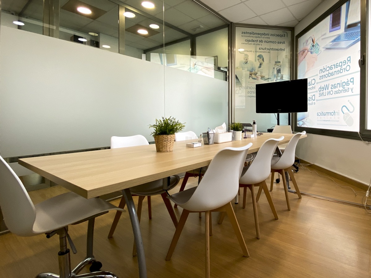 Meeting room with table, white chairs and TV screen in Oleiros
